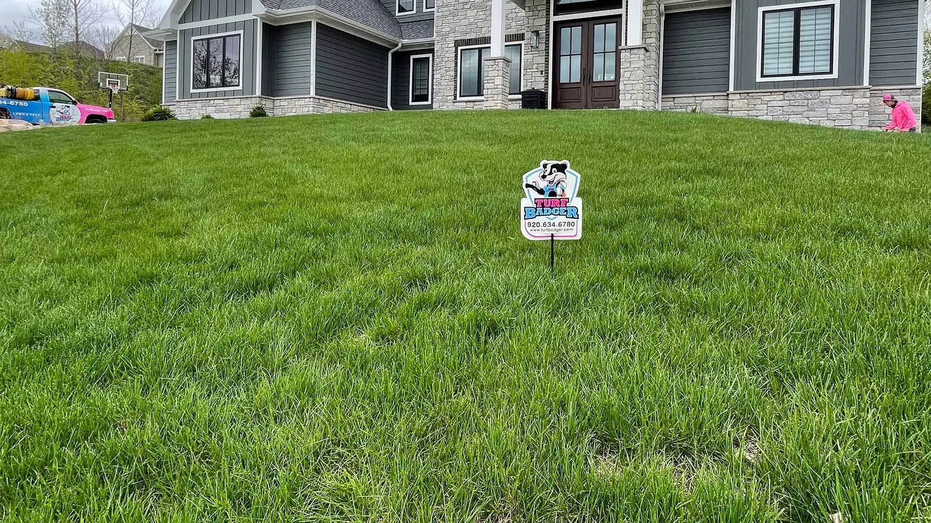 Lush, thick lawn grass and Turf Badger worker with truck at a home near Appleton, Wisconsin.