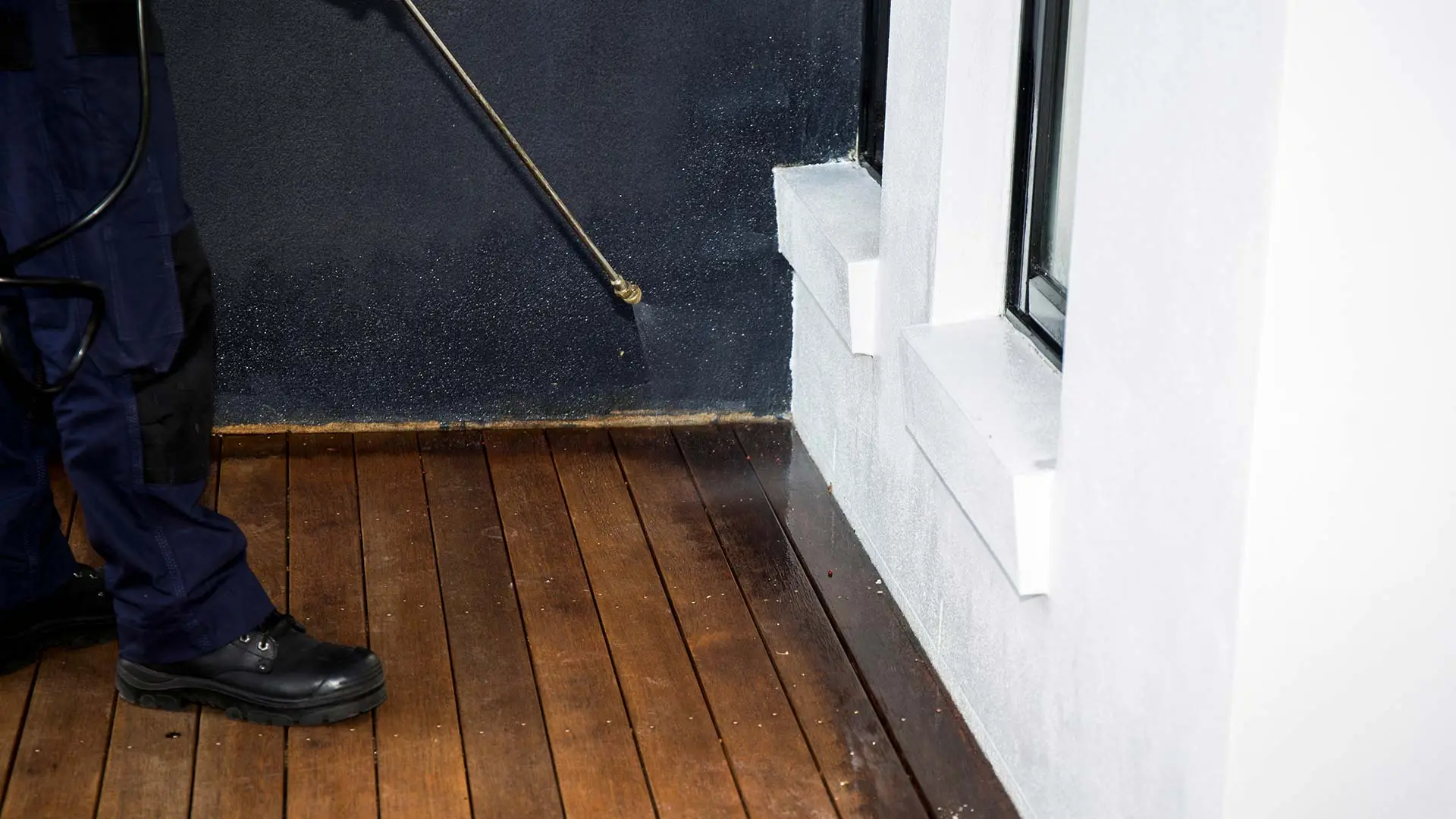 Professional applying perimeter pest control treatment in Escanaba, MI.