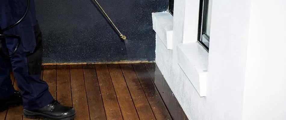 Perimeter pest control treatment being applied around patio of a home near Escanaba, MI.