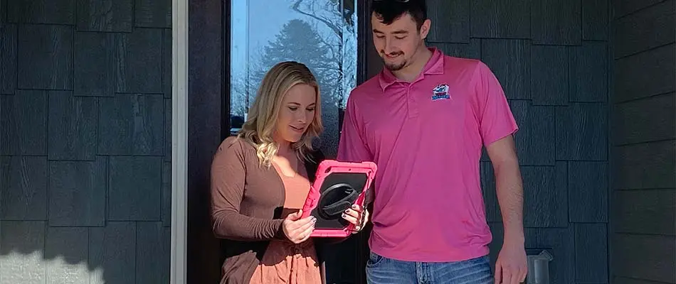 Turf Badger customer reviewing services on a tablet near Ashwaubenon, WI.