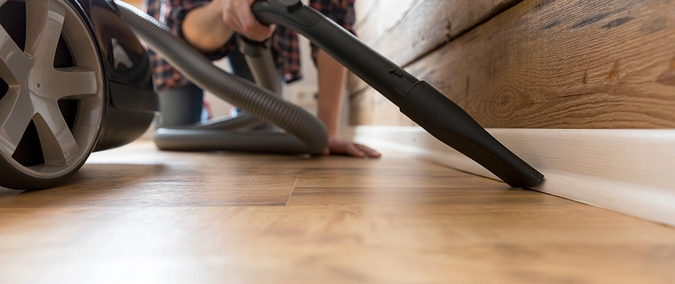 Person vacuuming crevice in floor in Green Bay, WI. 